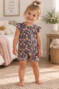A toddler girl in a navy floral romper from Australian brand Little Acres co