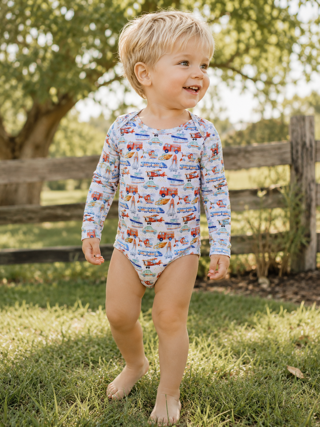 Toddler wearing Little Acres Co transport print organic cotton long sleeve bodysuit