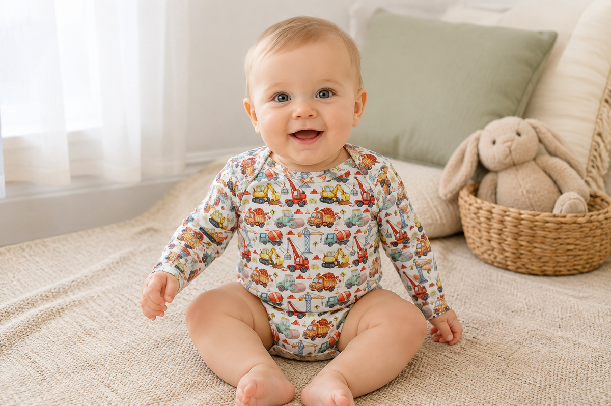 Baby wearing Little Acres Co construction print organic cotton long sleeve bodysuit