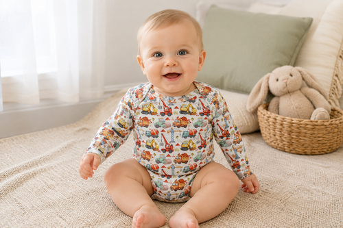 Baby wearing Little Acres Co construction print organic cotton long sleeve bodysuit