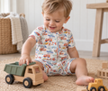 Little boy playing in Little Acres Co transport print organic cotton zip-up romper