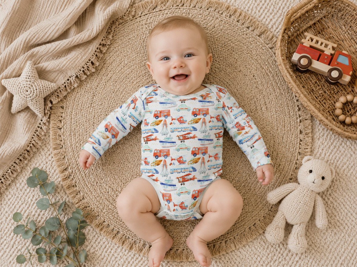Baby wearing Little Acres Co transport print GOTS organic cotton long sleeve bodysuit